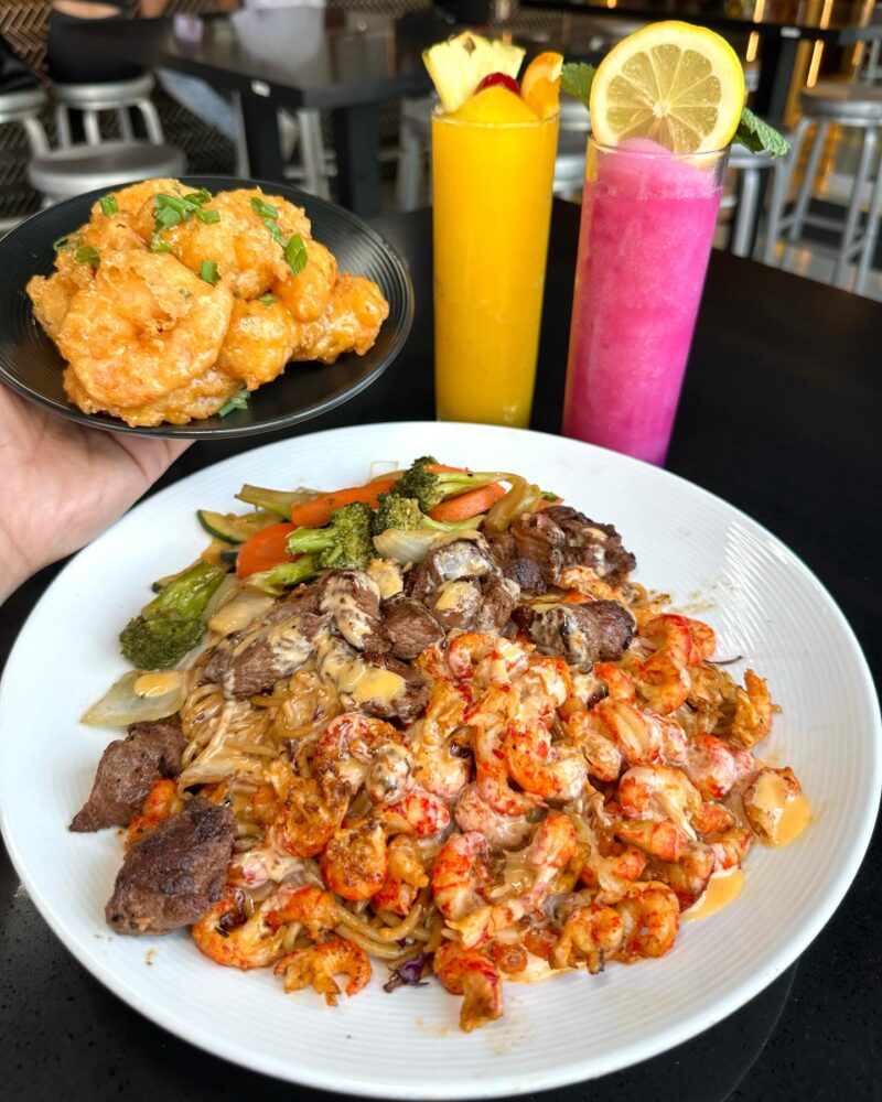 A plate of food and two drinks at Stick Talk Hibachi Cajun