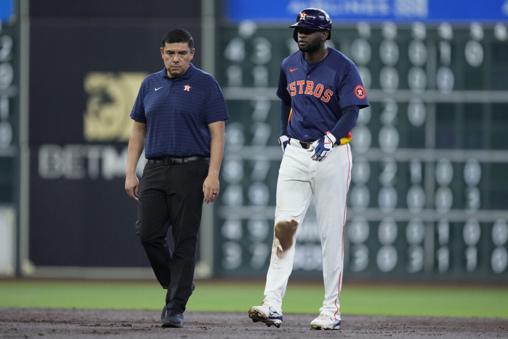 Photo of baseball player Yordan Alvarez walking off field after injury.