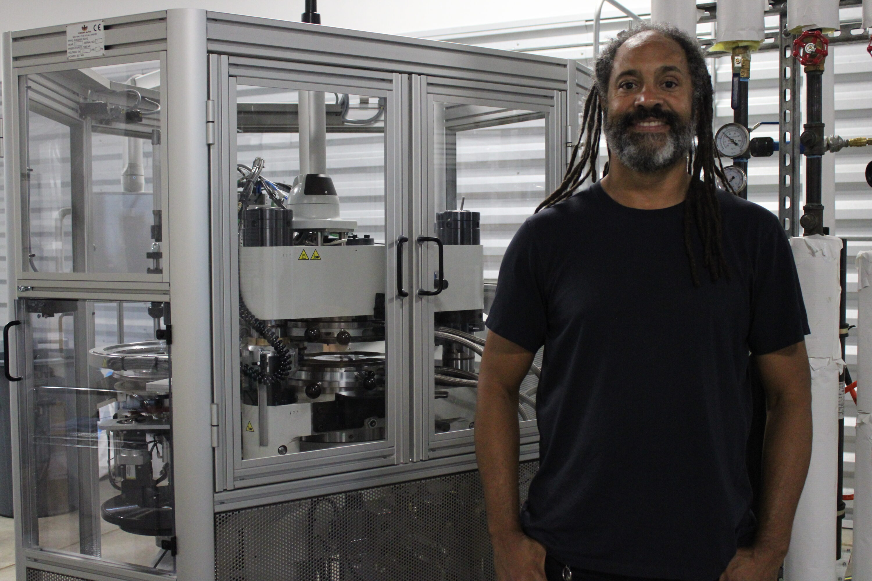 Joel Hoyle next to one of two machines he uses to press vinyl records.