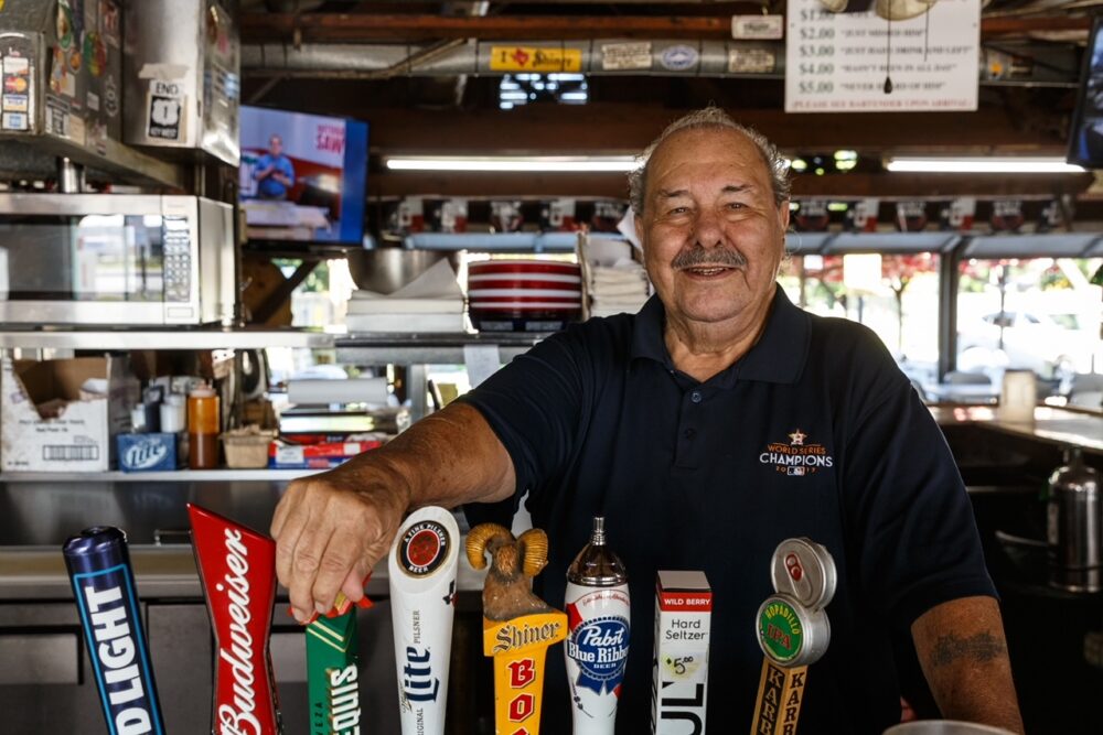 Carlos Villagomez behind the bar at his beer garden in Webster, Texas.