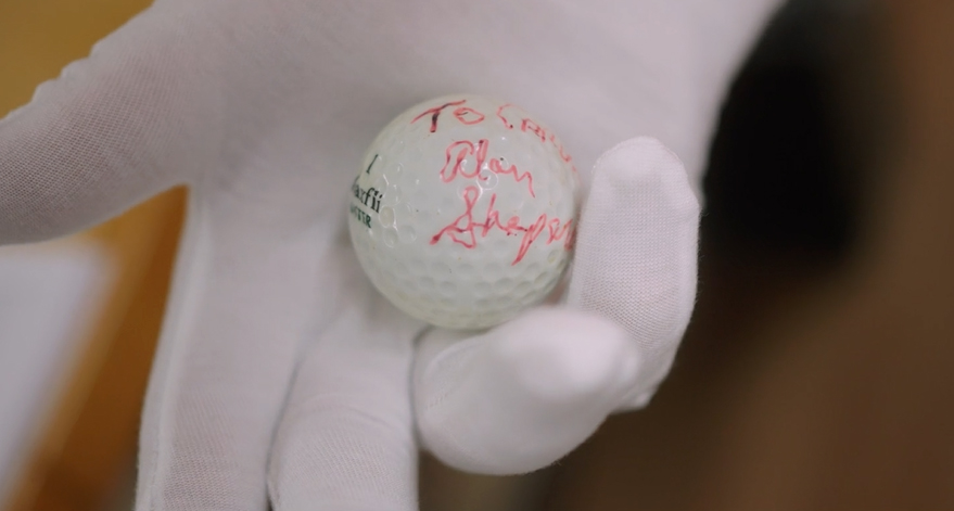 a close up of hands holding a golf ball