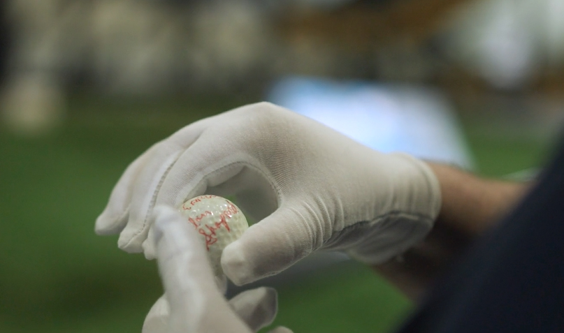 a close up of hands holding a golf ball