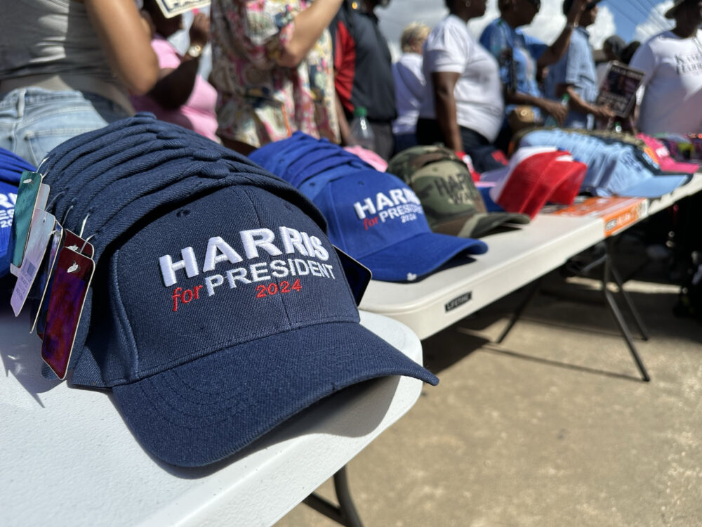 People sell Harris Walz merchandise in front of Shell Stadium before the vice president's stop in Houston. (Image credit: Lucio Vasquez)