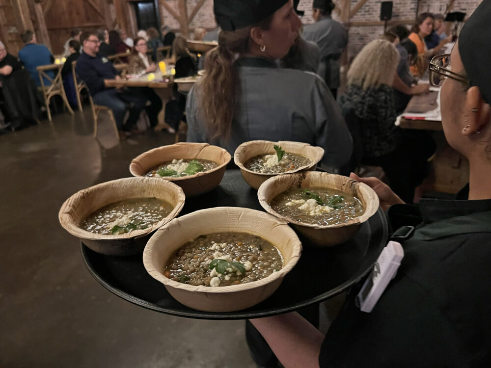 Servers bring out dishes of lentil soup. (Photo Credit: Michael Hagerty/Houston Public Media)