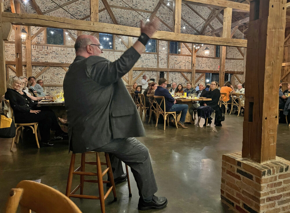 A storyteller regales diners with a tale about a medieval knight between dinner courses. (Photo Credit: Michael Hagerty/Houston Public Media)