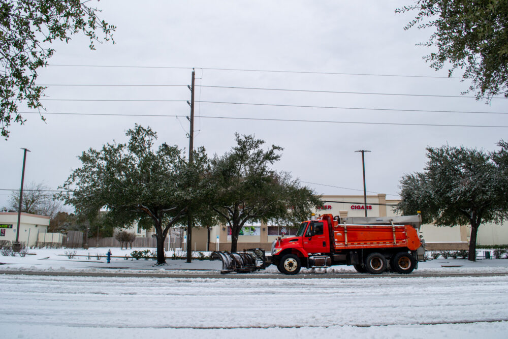 A snow plow clears a section of Main Street near NRG Stadium on Tuesday, Jan. 21, 2025. (Photo Credit: Kyle McClenagan/Houston Public Media)