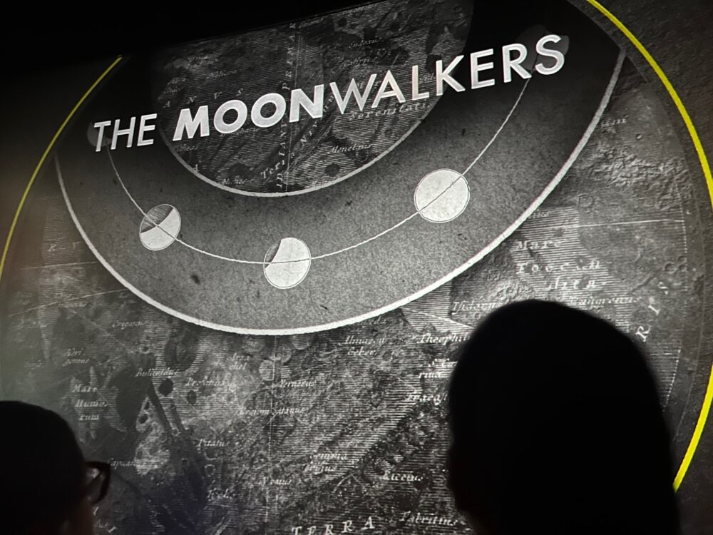 Dua anggota audiens bersiap untuk melihat Moonwalkers: Perjalanan dengan Tom Hanks, yang sekarang bermain di Houston Space Center. (Kredit Foto: Foto Brenda Valdivia)