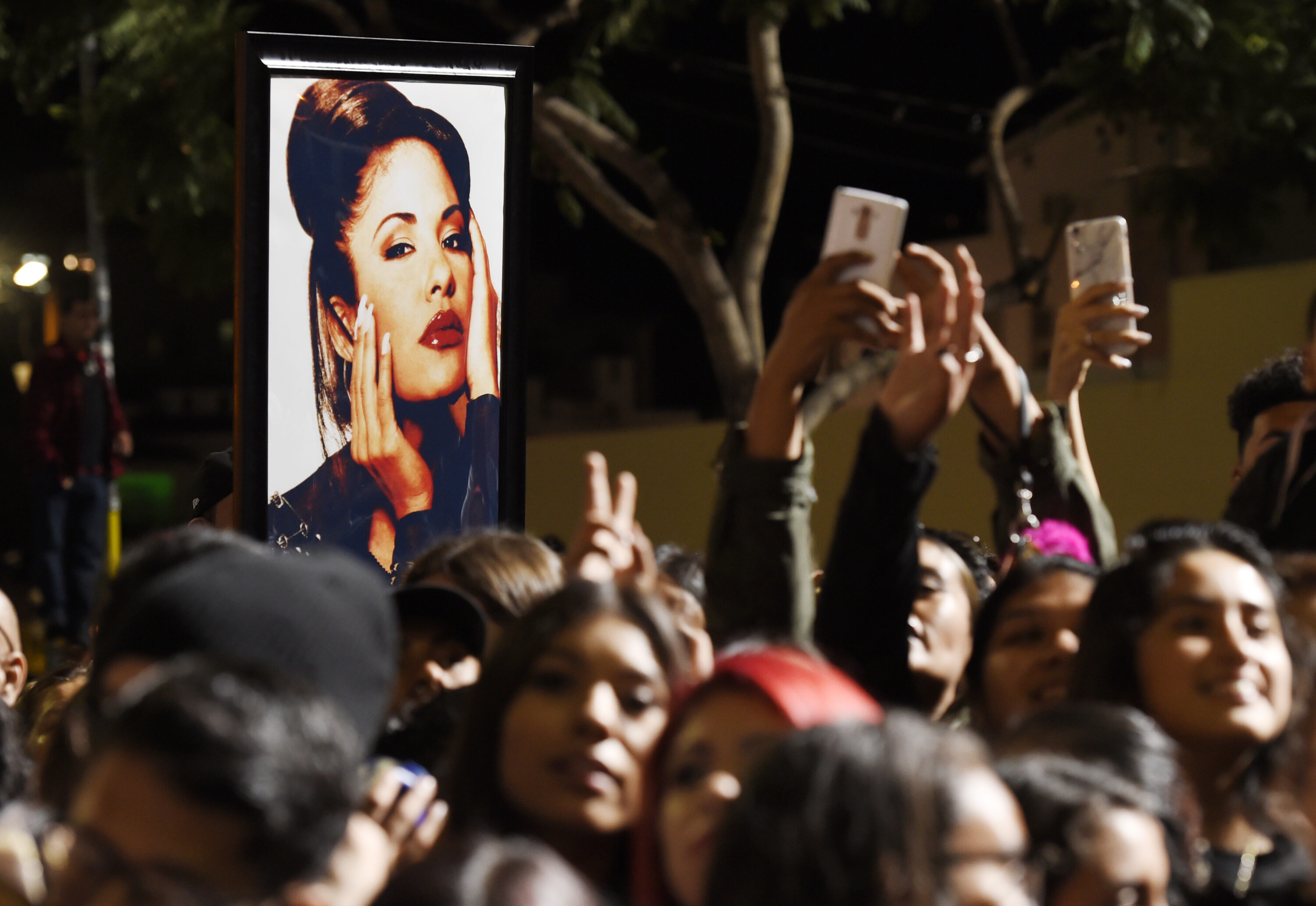 FILE - A portrait of the late singer Selena Quintanilla is seen in the crowd following a posthumous star ceremony for Quintanilla on the Hollywood Walk of Fame on Friday, Nov. 3, 2017, in Los Angeles. (Photo by Chris Pizzello/Invision/AP, File)