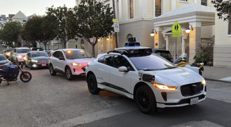 A Waymo driverless taxi stops on a street in San Francisco for several minutes because the back door was not completely shut, while traffic backs up behind it, on Feb. 15, 2023. (AP Photo/Terry Chea)