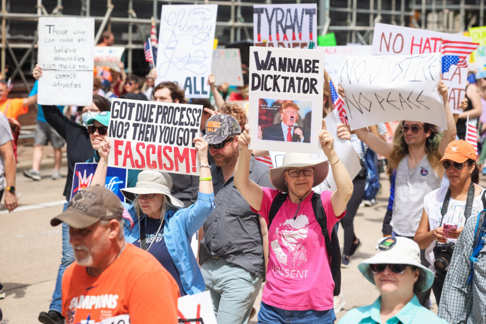 Para pengunjuk rasa memegang tanda -tanda dari lawan Donald Trump selama a 