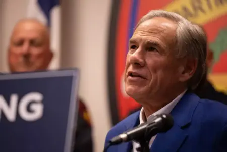 A man sits in front of a microphone as he talks to someone off camera.