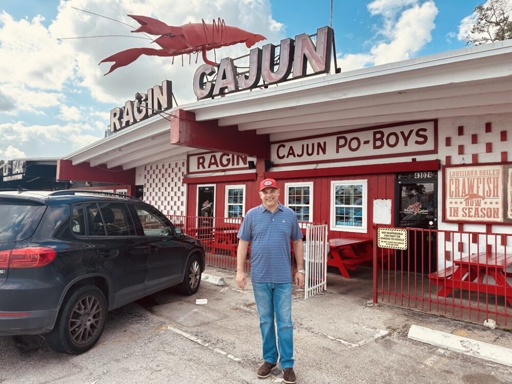 Dominic Mandola, owner of the Ragin’ Cajun in Houston, poses for a photo outside his restaurant on Tuesday, April 14, 2026. (Photo Credit: Natalie Weber / Houston Public Media)