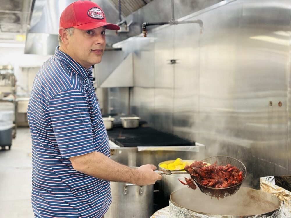 Dominic Mandola, owner of the Ragin’ Cajun in Houston, poses for a photo in his restaurant on Tuesday, April 14, 2026. (Photo Credit: Natalie Weber / Houston Public Media)
