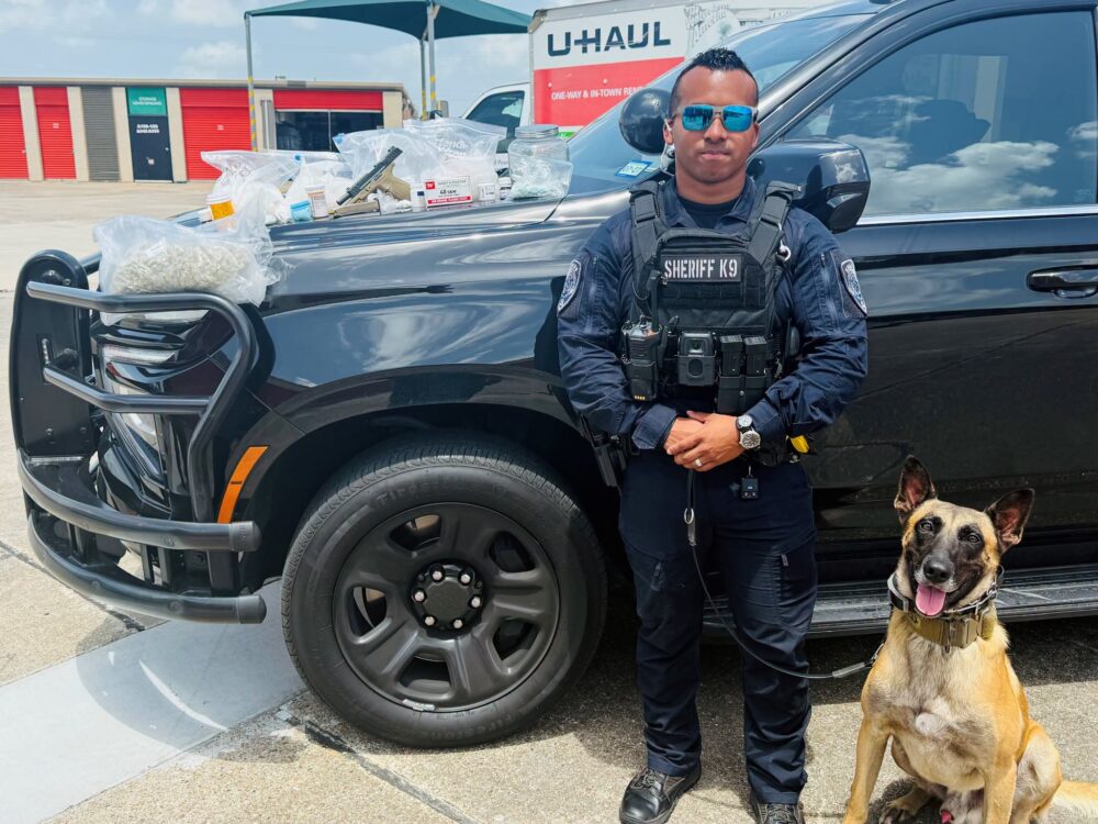 A Galveston County K9 deputy stands with his K9 after solving a months-long investigation.