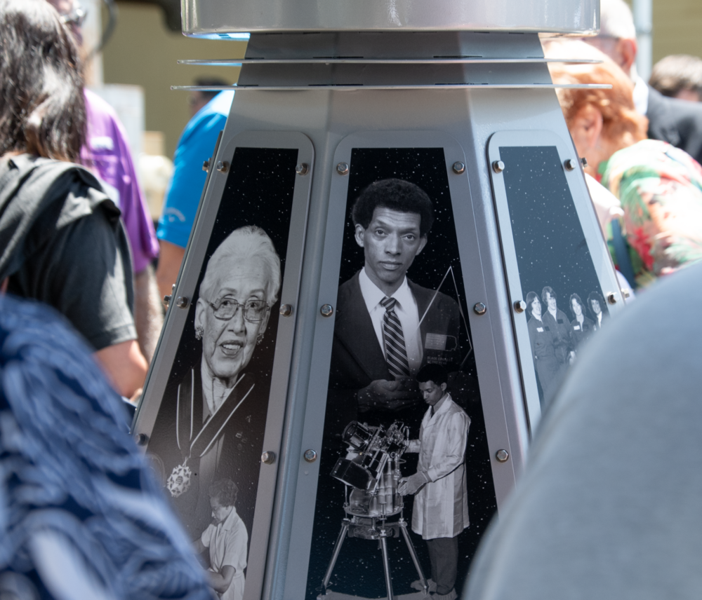 Black-and-white images of two space pioneers on the side of a monument