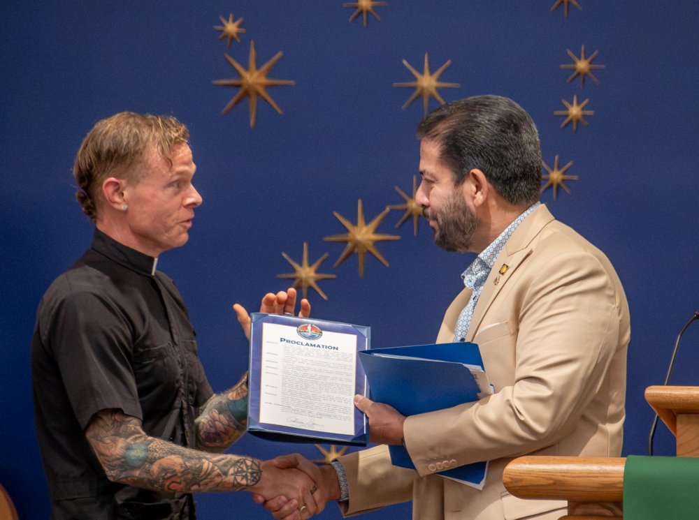 Harris County Commissioner Adrian Garcia presents a proclamation to Rev. Mike Stone, rector at St. Thomas the Apostle Episcopal Church in Nassau Bay, in recognition of the church's new monument to women and Black pioneers in the space industry. (Photo Credit: Daniel Villarreal/Episcopal Diocese of Texas)